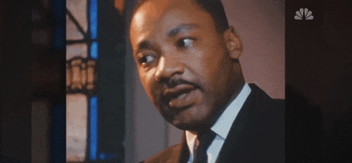 a close up of a man in a suit and tie talking