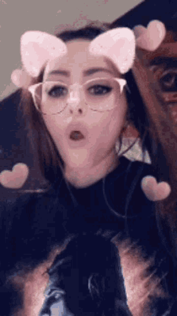 a woman wearing glasses and cat ears is making a funny face