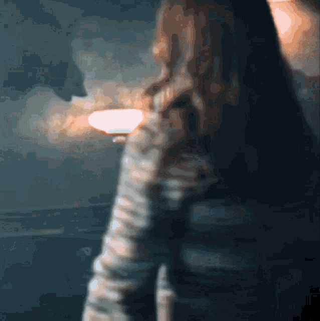 a blurry picture of a woman holding a light in her hand
