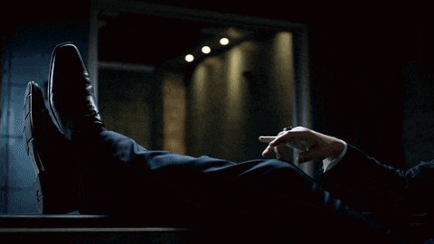 a man in a suit is smoking a cigarette