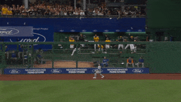 a man wearing a yellow gh jersey stands in the dugout