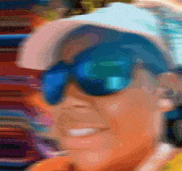 a blurry image of a person wearing sunglasses and a hat