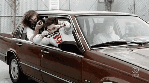 two men are sitting in a car with a comedy central logo on the hood