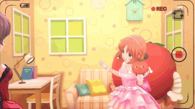 a girl in a pink dress is holding a stuffed tomato in a room with a rec button