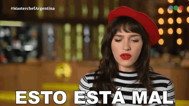 a woman wearing a red beret and striped shirt says esto esta mal