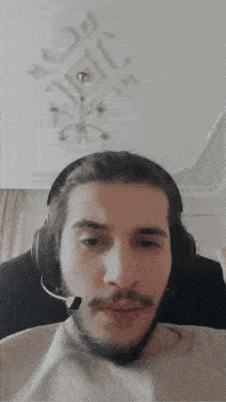 a man wearing headphones and a microphone looks at the camera