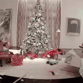 a christmas tree in a living room with gifts underneath it