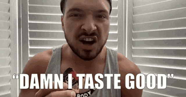 a man with a beard is eating a candy bar and says `` damn i taste good '' .