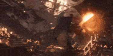 a man is standing in front of an explosion and holding a red cloth