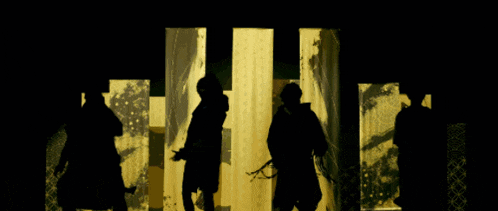 a man with a tattoo on his hand is standing in front of a yellow wall
