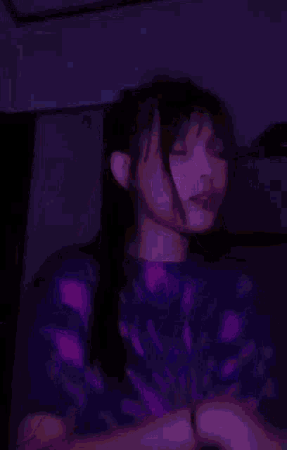 a girl wearing a tie dye shirt is making a peace sign with her hands .