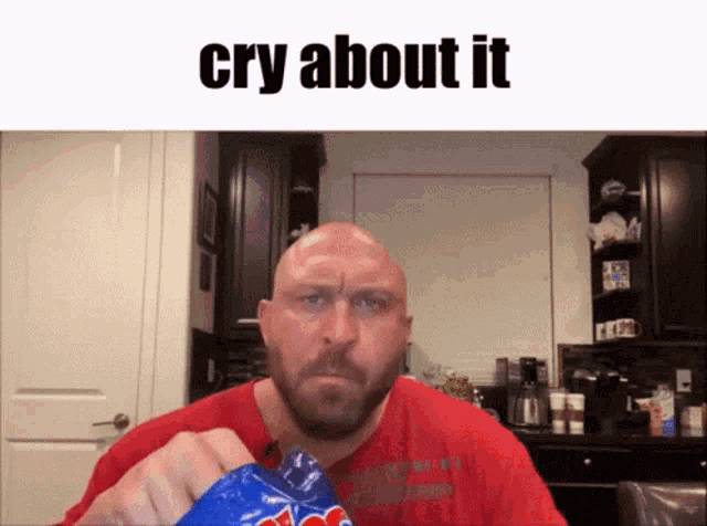 a bald man with a beard is holding a bag of m&m 's and crying about it