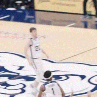 a basketball player wearing a number 2 jersey is dribbling the ball
