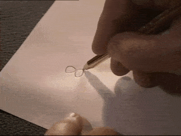 a person is drawing an infinity symbol on a piece of paper with a pen