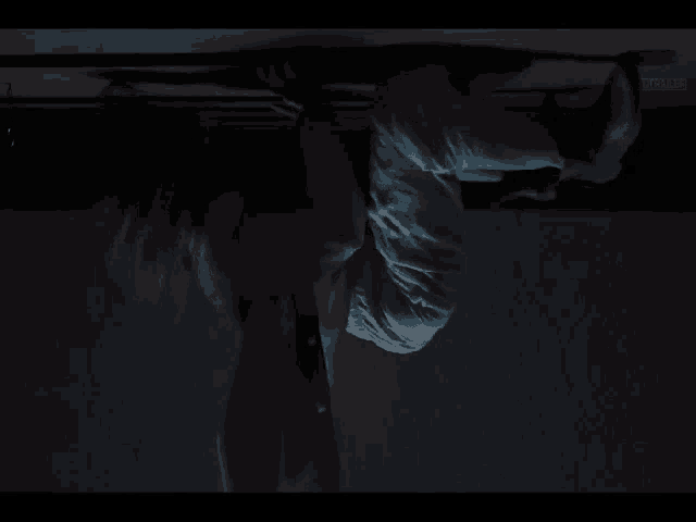a person is hanging upside down from a ceiling in a dark room