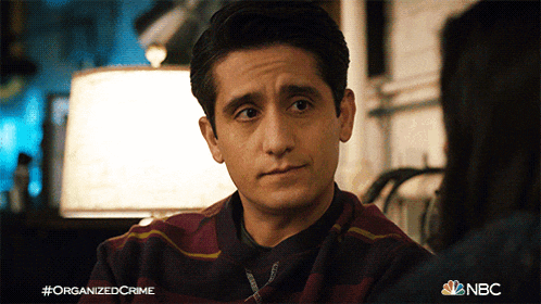 a man in a striped shirt is talking to a woman and the nbc logo is visible in the corner