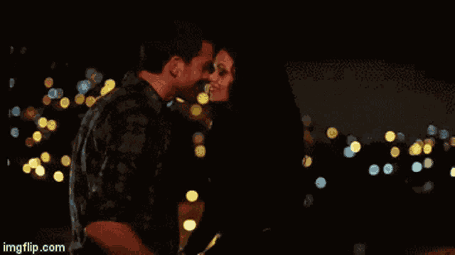 a man and a woman are dancing in front of a city at night with imgflip.com at the bottom of the screen