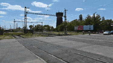 a train track with a billboard that says ' coca-cola ' on it