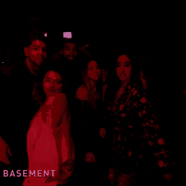 a group of people are dancing in a dark room with the words basement visible