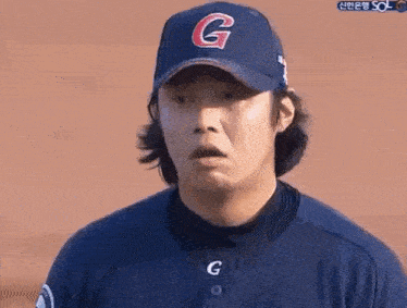 a man wearing a baseball cap with the letter g on it .
