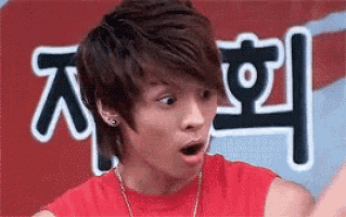 a young man in a red tank top is making a funny face .