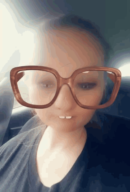 a woman wearing glasses and a black shirt looks at the camera