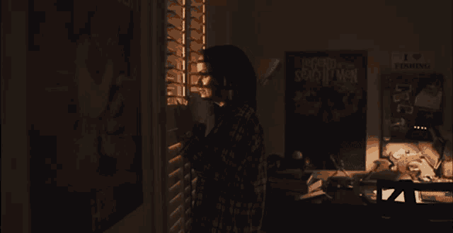 a person looking out a window in a dark room