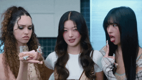 three girls are standing next to each other with one holding a bottle
