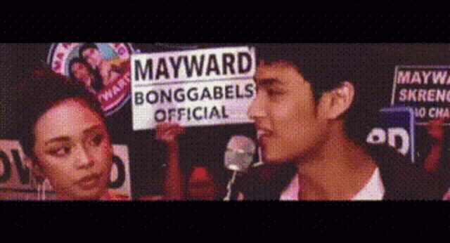 a man holding a sign that says mayward bonggabels official
