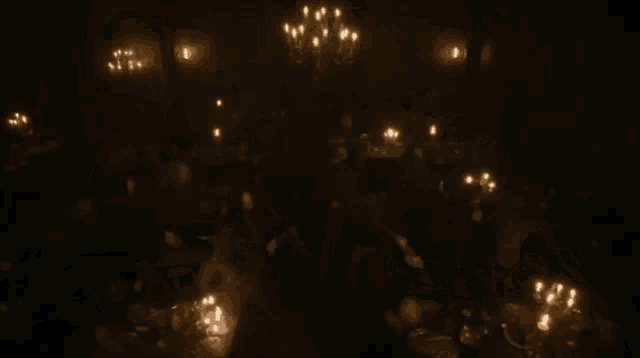 a group of people sitting around a table with candles