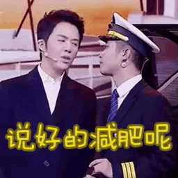 two men in suits and hats are standing next to each other . one of the men is wearing a microphone .