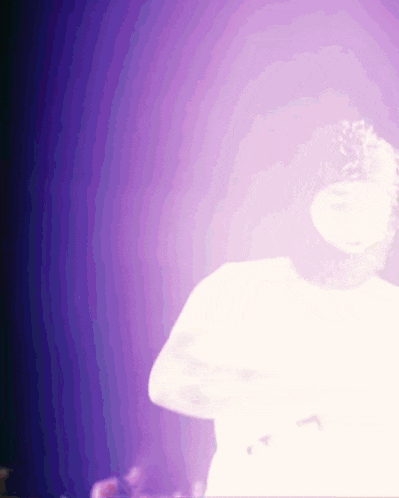 a blurry picture of a person in a white shirt against a purple background