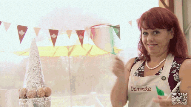 a woman wearing a white apron that says dominike on it