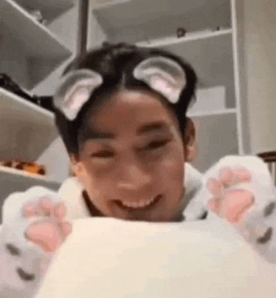 a man wearing cat ears and paws is smiling while holding a piece of paper .