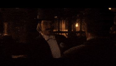 three men in tuxedos are standing next to each other in a dark room