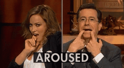 a man and a woman are making funny faces in front of a sign that says arused .