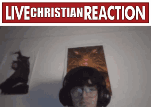 a man wearing headphones stands in front of a live christian reaction sign