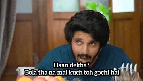 a man sitting at a table with the words haan dekha bola tha na mai kuch toh gochi hai above him