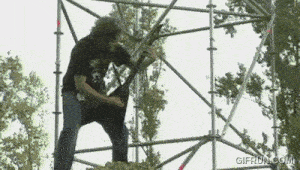a man playing a guitar on top of a scaffolding with gifrun.com written on the bottom right