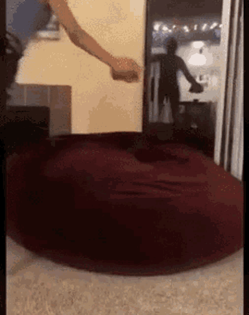 a person is sitting on a bean bag chair in front of a tv