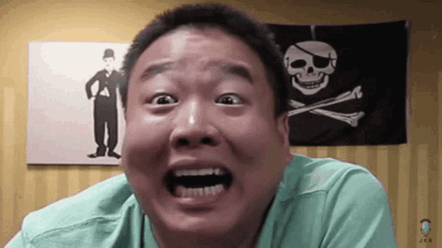 a man making a funny face with a pirate flag in the background