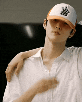 a man wearing a white shirt and an orange hat with the letter a on it