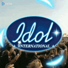 a crowd of people are gathered in front of a idol international logo