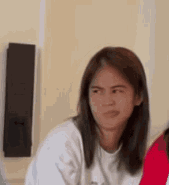 a young woman is making a funny face while sitting at a table in a living room .