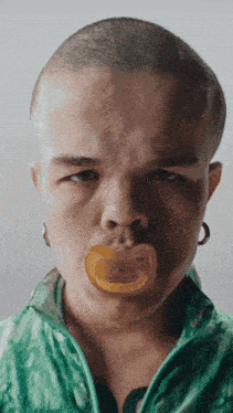 a person with a pacifier in their mouth and a green jacket