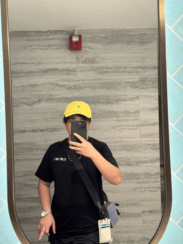 a person taking a selfie in front of a mirror with the word world written on their shirt