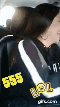 a woman is sitting in the back seat of a car with 555 lol written on her shirt