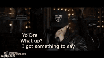 a man in a raiders hat is singing into a microphone