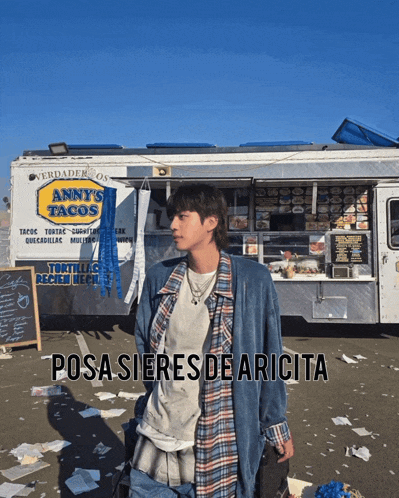 a man standing in front of a taco truck that says anny 's tacos