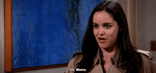 a woman says oh mama in front of a blue painting